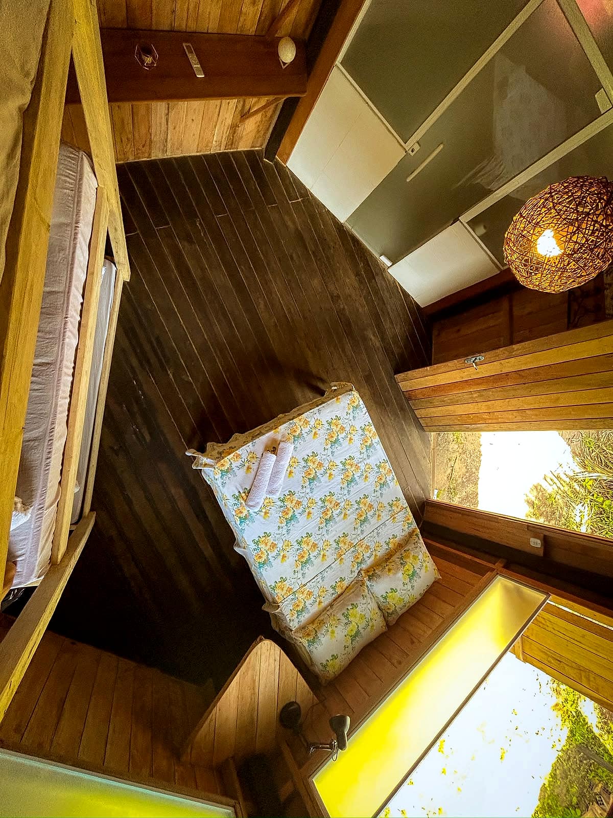 Cama de casal vista do alto, com janela para a área externa